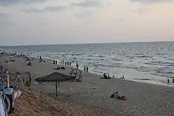 A photo of a sandy beach with relaxing beachgoers