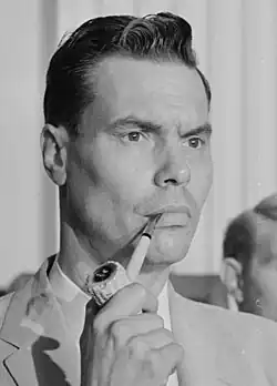 black and white closeup photo of Rockwell holding a corncob pipe