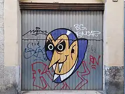 Graffiti image of Dracula, with large fangs, spray-painted onto a shutter