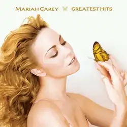Carey in golden hair holding a golden-colored butterfly.