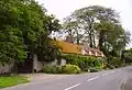 Hatford Cottage, with the former Holy Trinity parish church to the right