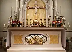 A statue of St. John Vianney is visible on the left side of the photo