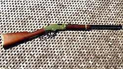 Image of a Henry Golden Boy rifle laying on a wooden floor.