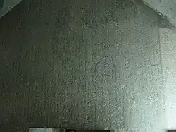 A photograph taken inside the substructure of Teti I's pyramid, showing long lines of hieroglyphic text that cover the entire wall and gable of the room.