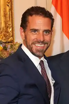 Headshot of Hunter Biden, a white, middle-aged man with dark hair and beard wearing a morning suit, smiling at the camera.