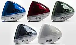 Side view arrangement of five iMacs, in clear dark blue, red, green, gray, and a frosted white.