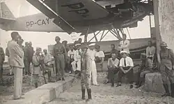 Communist civilians and rebel soldiers stand guard near the captured aircraft