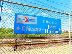 Blue sign attached to chain-link fence