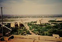 The Niger river, with a bridge. The background has some small buildings, while some multi-storey buildings are closer to the camera.