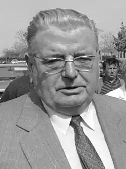 a man in a suit on the street while others look on