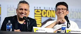 Joe and Anthony Russo speaking into microphones at Comic-Con in 2019