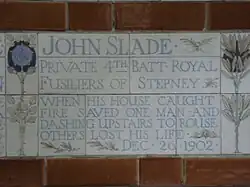 A tablet formed of five tiles of varying sizes, bordered by yellow and blue flowers in an art nouveau style