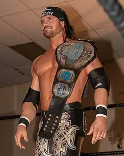 Johnny Impact with the fifth design of the belt, introduced in 2018, in its original blue-painted version.