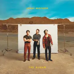 Cover artwork of The Album, a picture showing the band members in front of a white photography backdrop, on a canyon landscape