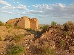 an old watermill with a background of a desert