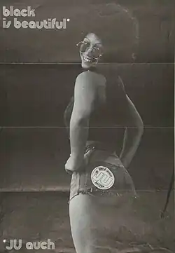 A Black is Beautiful poster featuring a Black woman with an afro looking back to the camera whilst smiling.