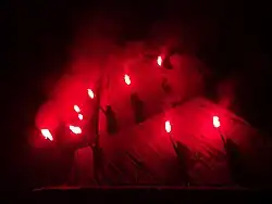 West's dancers hold glowsticks across the mountain