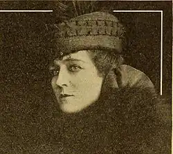 A woman with fair skin, wearing a hat
