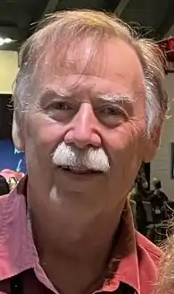 Man with gray mustache wearing a red shirt