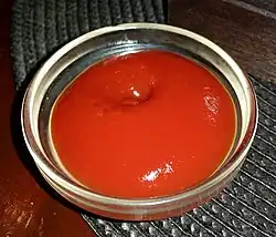 Glass dish of tomato ketchup