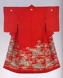A scarlet red kimono with short sleeves viewed from the back. The kimono is lined in a different, warmer shade of red, and has a padded hem. The kimono has three crests along the shoulders, and is decorated with a design of hazy mist and hanging scroll motifs along the hem, reaching higher towards the front of each side.