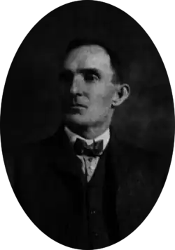 Bust portrait of a man in a late nineteenth century, three-piece suit and bow-tie, looking off to his right