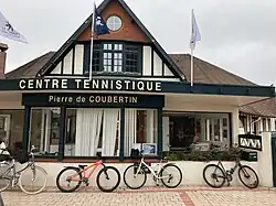Entrance to a building that says "Centre Tennistique Pierre de Coubertin"