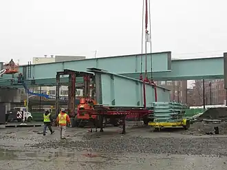 A large steel beam being lifted onto a viaduct