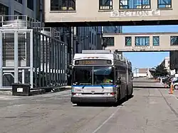 A silver-painted bus in an industrial area