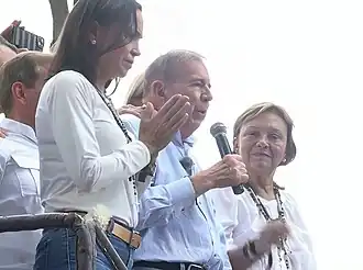 María Corina Machado and Edmundo González along with his wife, addressing supporters in Caracas following the 2024 presidential election results. Incumbent Nicolás Maduro secured a third term in an election widely criticized as neither free or fair, given the Maduro administration having controlled most institutions and repressed the political opposition before and during the election.