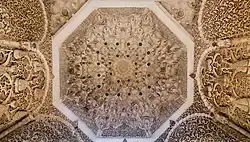 The muqarnas dome inside the mihrab; the sides are also covered in carved stucco with arabesque and pine cone motifs