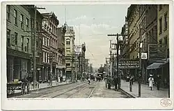 Hand-colored photograph with horses along Main Street