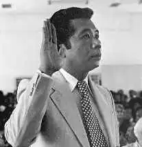 A photograph of Nakamura in profile from the right raising his right hand.