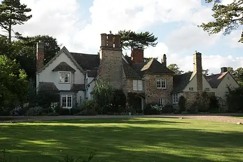 A large farmhouse with many red-brick chimneys