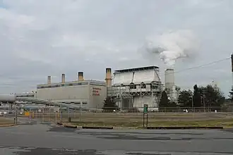 A steam station with a large cooling tower expelling a cloud of vapor