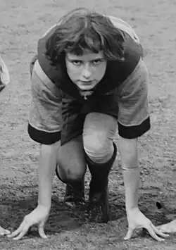 A young white woman with bobbed dark hair, on the starting line of a running race