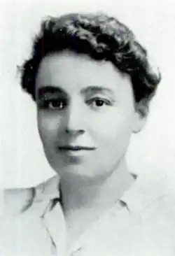 A white woman with short dark curly hair