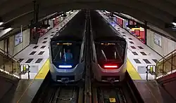 Two Montreal Metro trains stopped at a station.