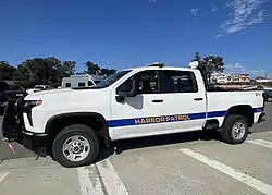 A photograph of a white pickup truck with "Harbor Patrol" written on the side in yellow letters.