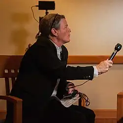 woman holds up microphone