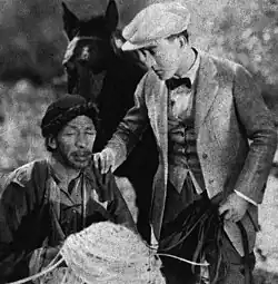 Black and white film still showing two men in period Asian costume