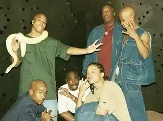 The group in 1996. Standing: Napoleon, E.D.I. Mean, and Hussein Fatal; Below: Kastro, 2Pac, and Yaki Kadafi