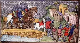 A medieval image of a group of mounted knights crossing a wooden bridge