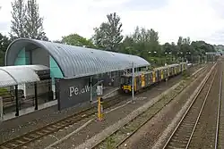 An aerial view of Pelaw metro station with railway tracks and a metro stopped at the platform.