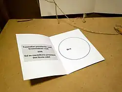 A blank ballot piece of folded card with an empty circle printed on the right-side were voter have to write the unique number assigned to their preferred candidate.