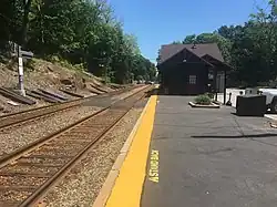 A low-level railway platform with a station building in the background