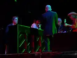 Musicians huddled around a piano