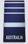 A black shoulder board with the word "AUSTRALIA" across the bottom. Above the word is a thick, blue horizontal stripe, with three thinner blue horizontal stripes above that.