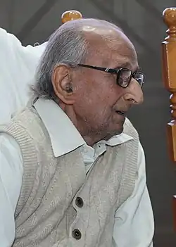 Headshot of Gupta looking left, wearing glasses
