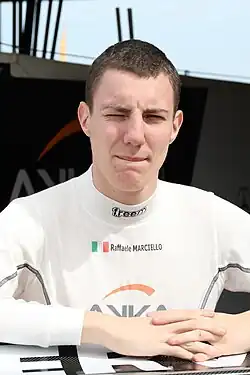 Raffaele Marciello sporting short hair and wearing a white fireproof vest bearing his name, country and two sponsors logos